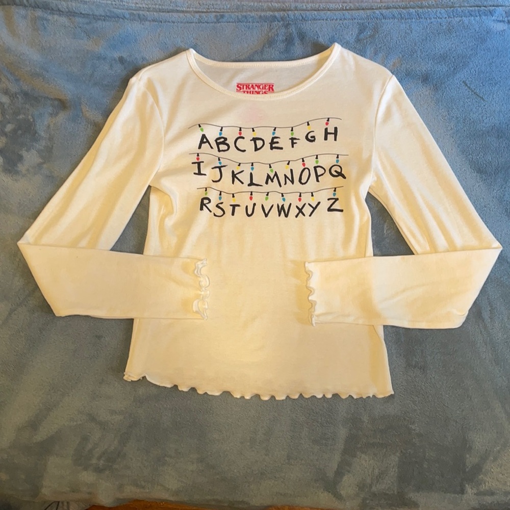 Cream colored stranger things lights shirt.